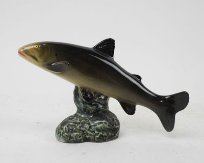 figurine of a fish on a rock on a white background