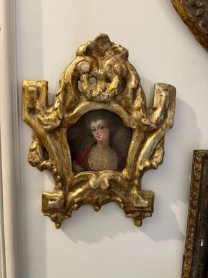 a gold frame with a picture of a woman in a red dress