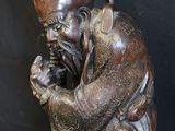 statue of a man with a beard and a hat on a black background