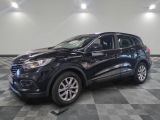 Un SUV noir est garé sur un sol à damier dans un garage.
