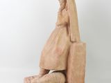 a statue of a woman sitting on a chair with a veil on her head