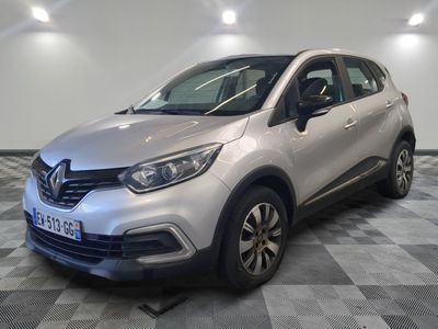 une voiture argentée garée dans une pièce au sol en damier