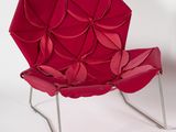 a red chair that is sitting on a white surface