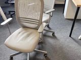 une chaise de bureau blanche placée devant un bureau d'ordinateur