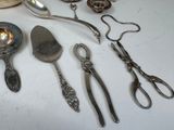 a lot of silver spoons and utensils sitting on a table