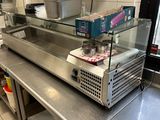 plan de travail en acier inoxydable dans une cuisine professionnelle équipée de fours à micro-ondes et d'autres appareils électroménagers