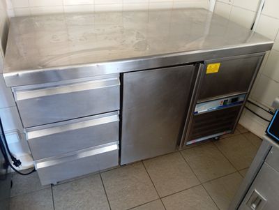 a stainless steel counter in a kitchen with a refrigerator