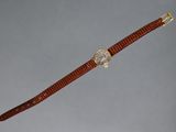 a close up of a wrist watch with a brown strap