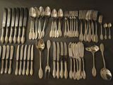 un grand nombre de cuillères et de fourchettes disposées sur une table