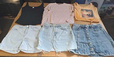 a lot of shorts and t - shirts laid out on a table