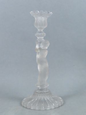 un bougeoir en verre transparent posé sur une table