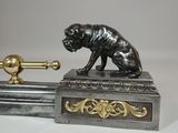 bronze figurine of a dog sitting on top of a sword