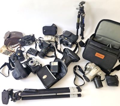 tout un tas d'appareils photo et d'accessoires différents posés sur la table