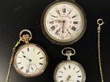 trois types différents de montres de poche exposées sur un socle noir