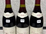 trois bouteilles de vin posées les unes à côté des autres sur un comptoir