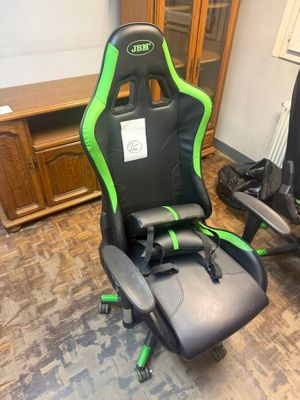 a green and black racing chair in the corner of a room