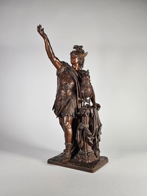 une statue en bronze représentant un homme tenant un enfant et un chien dans ses bras