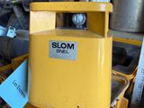 a yellow machine that is sitting on a pile of junk