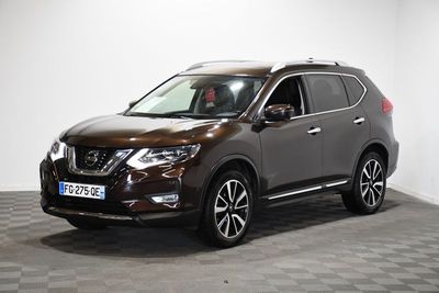 un SUV Nissan marron garé sur un sol à damier dans une pièce