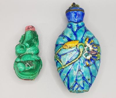 trois objets en verre de couleurs différentes sont disposés sur une surface blanche