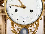 a gold clock with a picture of a lady on it