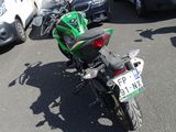 a green motorcycle parked in a parking lot next to a white van