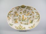 une image représentant une assiette jaune et verte ornée de fleurs et d'oiseaux