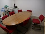 une photo d'une salle de réunion avec une table et des chaises rouges