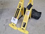 un panneau d'avertissement jaune posé par terre à côté d'un sac noir