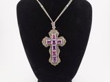 a necklace with a purple cross on a black mannequin