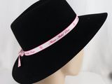 a black hat with a pink ribbon around the brim