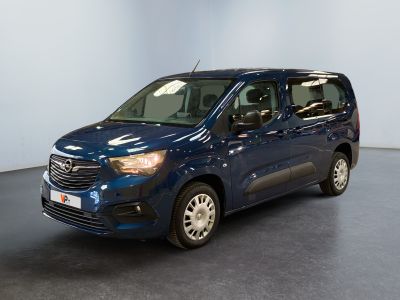 La camionnette bleue est garée dans une grande pièce au sol noir.