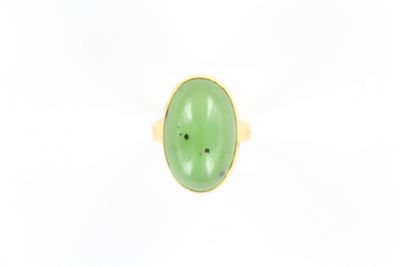 un gros plan d'un anneau vert sur une surface blanche