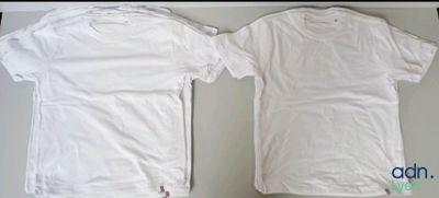 Deux t-shirts blancs sont posés l'un à côté de l'autre sur une table.