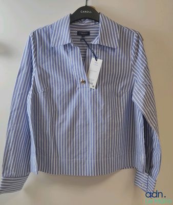 a close up of a shirt hanging on a hanger on a wall