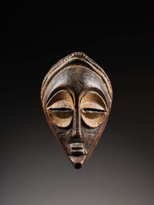 gros plan d'un masque en bois sur fond noir
