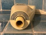 an image of a white electric hair dryer on a tiled floor