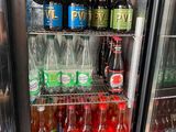 a refrigerator filled with bottles of soda and other drinks
