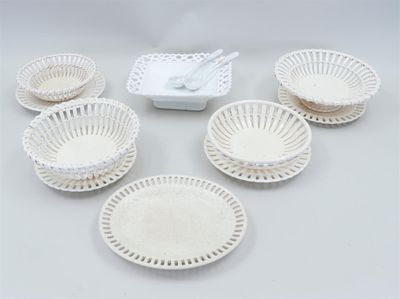 several white plastic bowls and plates are arranged on a table