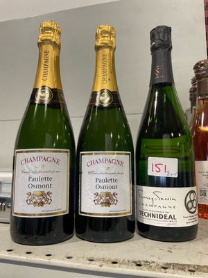 Trois bouteilles de champagne sont alignées sur un comptoir