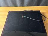 an image of a black stove top sitting on top of a wooden table