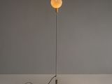un lampadaire avec un pied en verre et une ampoule au sommet