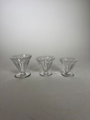 trois verres à pied en verre transparent posés sur une table
