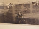 a black and white photo of a man riding a horse in the water