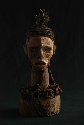 une vieille tête en bois surmontée d'une couronne