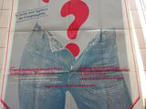 une grande affiche accrochée au mur d'un immeuble, sur laquelle figure un point d'interrogation