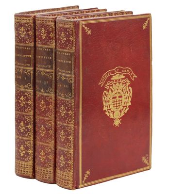 un lot de trois livres rouges ornés de motifs dorés