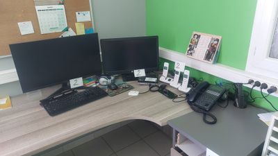 un bureau sur lequel se trouvent deux écrans d'ordinateur et un téléphone