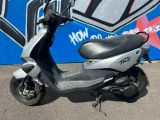 un scooter garé devant un mur recouvert de graffitis