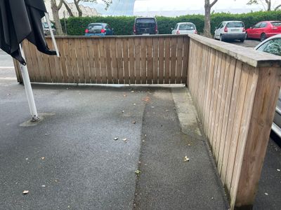 a wooden fence with a black umbrella on top of it